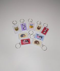 six keychains with pictures of animals on them are arranged in the shape of squares