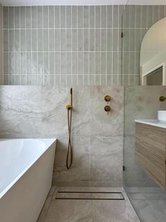 a white bath tub sitting next to a walk in shower