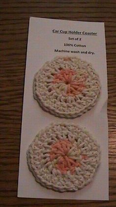 two crocheted coasters sitting on top of a wooden table