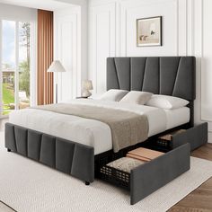 a bed with two drawers underneath it in a white and gray bedroom area next to a large window