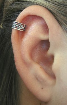 a close up of a person's ear with a ring on it