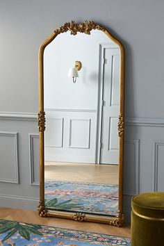 a large mirror sitting on top of a wooden floor