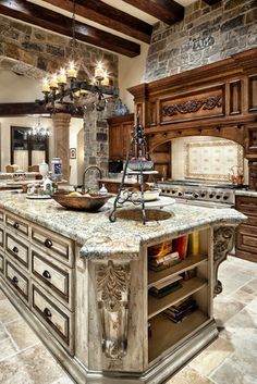 a large kitchen with an island in the center and two chandeliers hanging from the ceiling