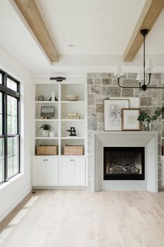 an empty living room with a fireplace and built - in bookshelves