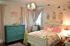 a bedroom decorated in pastel colors with pink and green accents