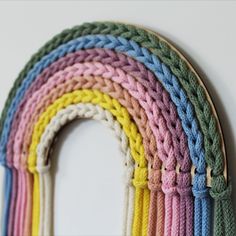 a rainbow wall hanging on the side of a white wall