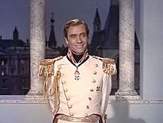 a man in uniform standing next to columns