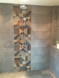 a bathroom with tiled walls and flooring in the shower area, including a hand held shower head