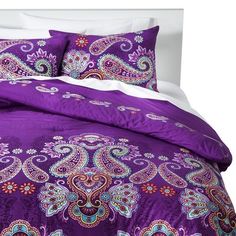 a bed with purple comforter and matching pillows