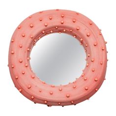 a round mirror with pink dots on it