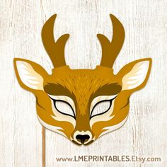 a deer mask with antlers on it's head is shown against a wooden background