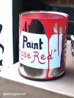 a red paint can sitting on top of a cardboard box