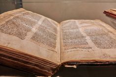 an old book with writing on it sitting on a table next to a glass case