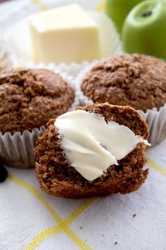 three muffins with white frosting on a table