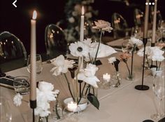 the table is set with white flowers and candles for an elegant dinner or reception party