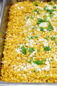 a metal pan filled with corn and parsley