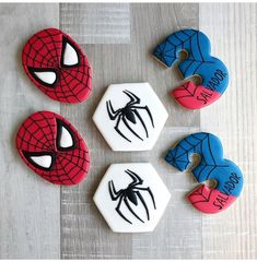 four decorated cookies with spiderman faces on them