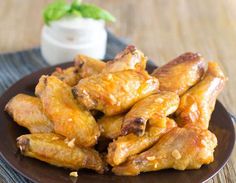 chicken wings on a plate with ranch dressing in the background