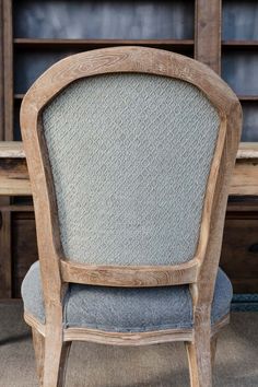 a wooden chair sitting in front of a book shelf