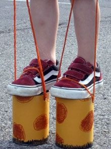 a person wearing red shoes standing on top of a pair of yellow containers with orange circles painted on them