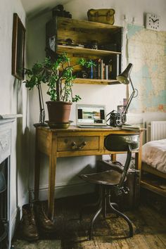 a desk with a potted plant sitting on top of it next to a fire place