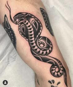 a black and white snake tattoo on the arm