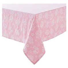 a pink tablecloth with white flowers on it and a light pink table cloth underneath the table