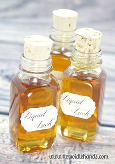 three small bottles filled with liquid sitting on top of a wooden table next to each other