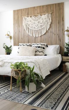 a white bed sitting next to a wooden headboard on top of a wall in a bedroom