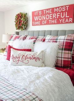 a bedroom decorated for christmas with red and white plaid bedding, holiday decorations and pillows