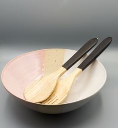 two wooden utensils in a white bowl