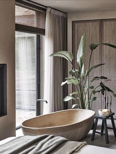 a bath tub sitting next to a window in a room with wooden walls and flooring