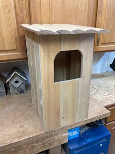 a wooden bird house sitting on top of a counter next to a blue tool box