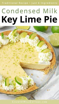 a key lime pie on a white table with limes in the background and text overlay that reads, condenseed milk key lime pie