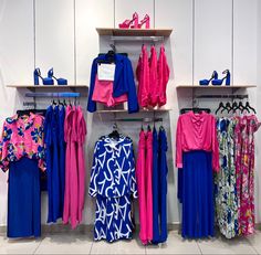 clothes and shoes are displayed on shelves in a store