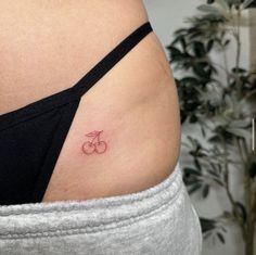 a woman's stomach with a small cherries tattoo on it