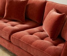 a red couch sitting on top of a hard wood floor