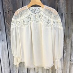 Rebecca Taylor Silk Chiffon Lace Blouse Cream 8 Super Cute Ultra Chic Romantic Feminine Flowy Silk Chiffon Blouse With Lace Detail Long Sleeve Tie Cuffs Round Neck Front Button Keyhole Lace Detail At Yokes And Shoulders Round Hem Lined 100% Silk Minimalist Minimalism Capsule Romantic Feminine Flowy Lightweight Boho Bohemian Approx Length 25” Pit To Pit 21” Great Condition Faint Stain On Tie Wear Once And Clean Smoke And Pet Free Home Feminine Chiffon Blouse For Brunch, Fall Chiffon Blouse For Brunch, Chiffon Blouse For Brunch In Fall, Elegant Airy Blouse For Summer, Chiffon Blouse With Blouson Sleeves, Sheer Chiffon Blouse For Work, Long Sleeve Chiffon Wedding Top, Chiffon Long Sleeve Wedding Top, Spring Chiffon Blouse With Blouson Sleeves