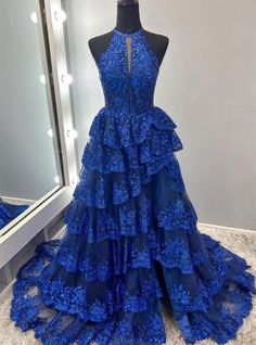 Knockout looks are guaranteed with this dazzling royal blue prom dress that epitomizes both modern glamor and timeless sophistication. The dress features an array of sparkling sequins and detailed floral motifs, creating a visually striking effect. A unique high neckline with a delicate keyhole offers a glimpse of allure, leading down to a fitted bodice that defines every curve. The tiered, ruffled skirt not only adds dramatic flair but also swings charmingly with each step, highlighted by a tasteful front slit that promises ease of movement. This gown is designed for those who wish to own the spotlight, ensuring a memorable impression at any prom or gala event. Feather Prom Dress, Tiered Prom Dress, Ruffle Gown, Tulle Material, Blue Corset, Corset Dress Prom, Tulle Ball Gown, Custom Size Dresses, Color Number