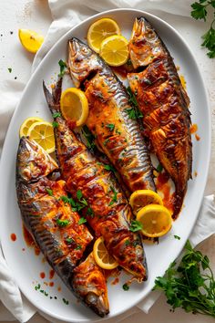 two fish on a plate with lemons and parsley