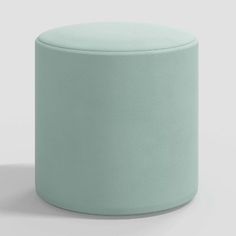 a light blue ottoman sitting on top of a white floor