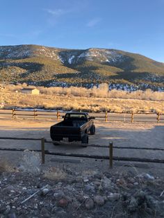 a black truck parked in front of a mountain