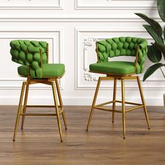 two green chairs sitting next to each other on top of a wooden floor