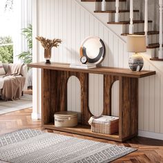 a wooden console table in a living room with stairs and potted plants on top