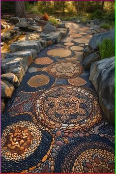 a pathway made out of rocks and stones with an artistic design on the walkway is surrounded by large boulders