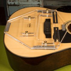 an acoustic guitar is shown with its case and accessories on the top shelf in front of it