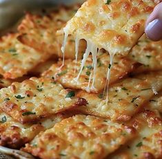 a person is taking a slice of cheesy pizza from a dish with cheese