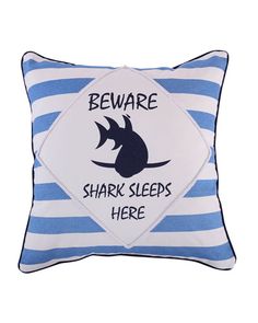 a blue and white striped pillow with a shark on it's side that says beware shark sleeps here