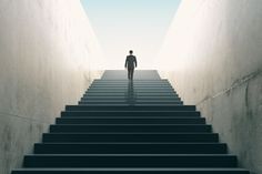 a man is walking up some stairs towards the light that shines down on him