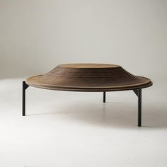 a wooden table sitting on top of a white floor next to a black metal frame